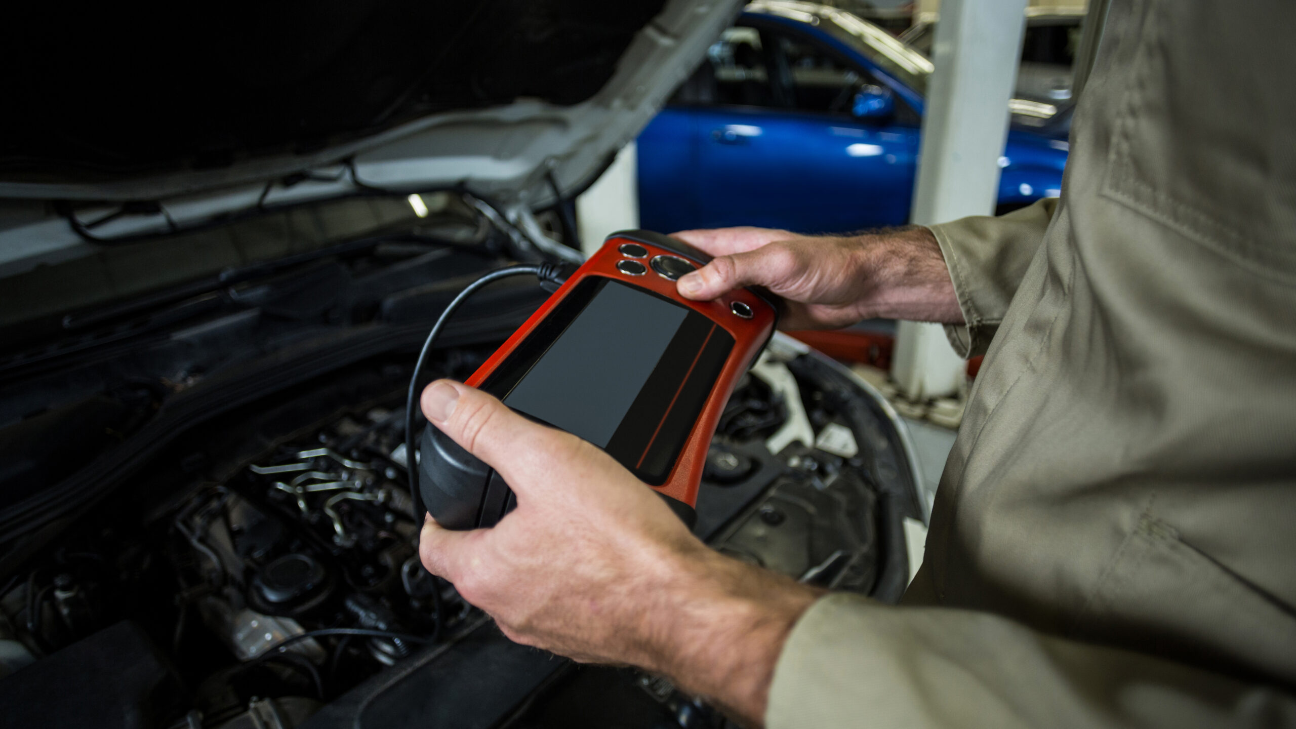 Hands of mechanic using a diagnostic tool